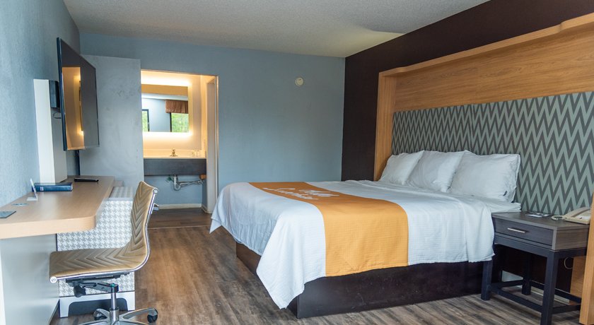 King Room at Columbus Inn and Suites — wide angle showing workspace, TV, and full layout